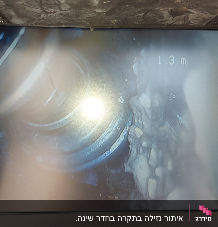 תצוגת מסך של מצלמת ביוב עם צינור ומרחק